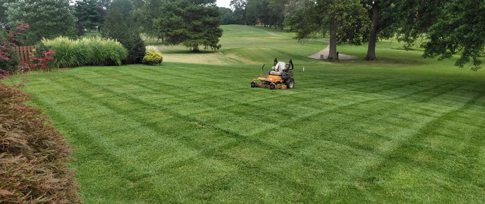 Mowed lawn with mower parked after service in Utica, IN.