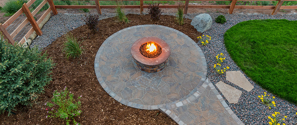 Mulch and rock topped landscape beds surrounding a patio and fire pit in St. Matthews, KY.